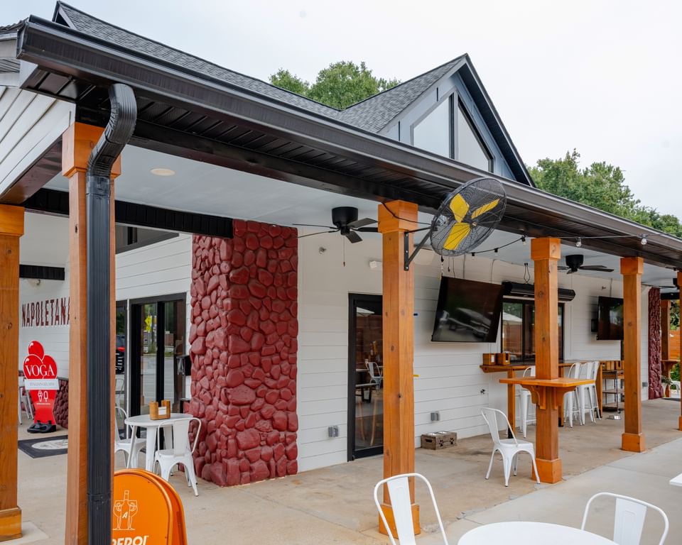 Voga Italian Gelato restaurant exterior with covered patio, wooden posts, outdoor seating, ceiling fans, and red stone columns.
