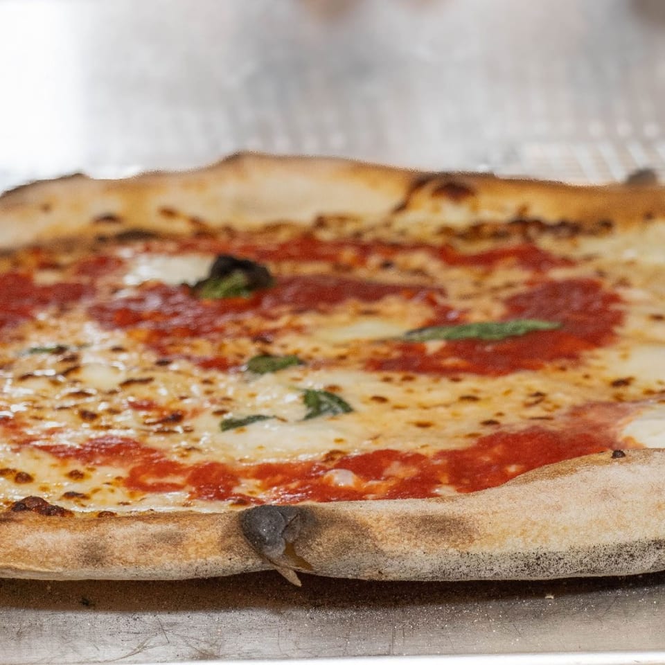 Freshly baked pizza with tomato sauce, melted cheese, and basil.